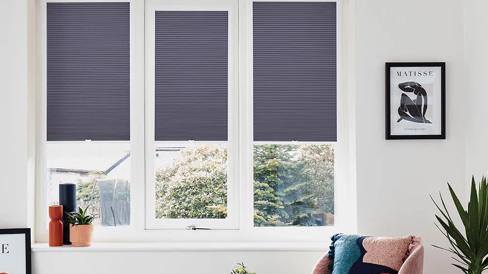 Dark blue pleated Perfect Fit blinds clipped neatly into white uPVC window frames in a modern living room